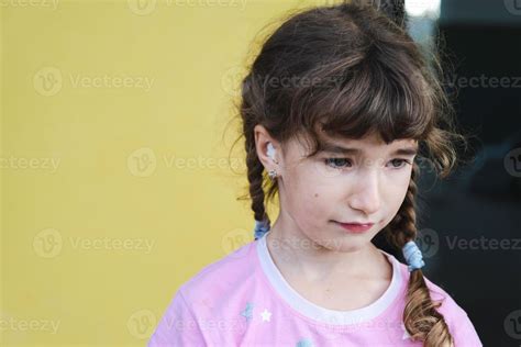 Girl with a warming therapeutic cotton swab in the ear with a sad and