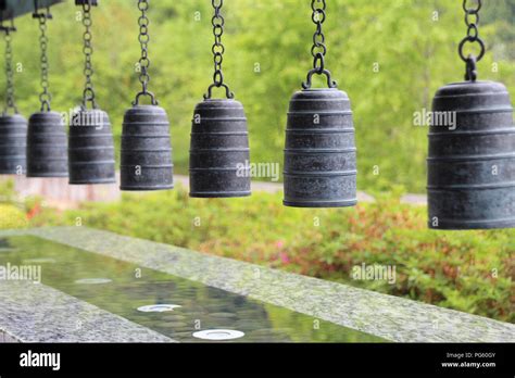 A Row Of Zen Style Hanging Bells In Buddhist Monastery With Green