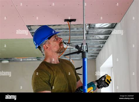 Construction Worker Wearing Tool Belt And Safety Equipment Using Power