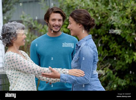 Femme mature avec jeune couple à l extérieur répondre Photo Stock Alamy
