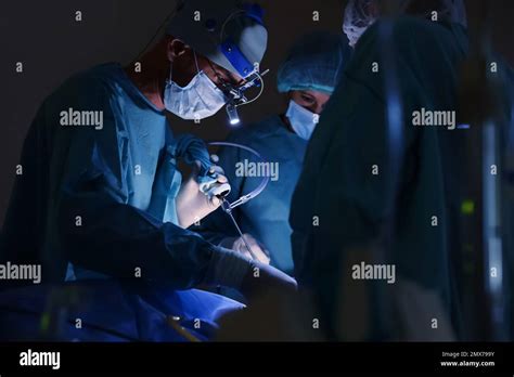 Team Of Professional Doctors Performing Operation In Surgery Room Stock