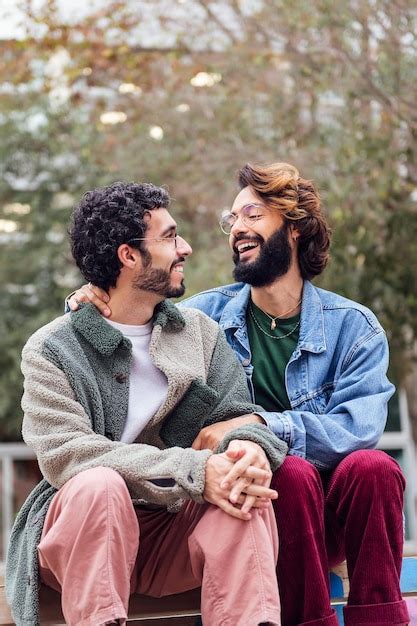 Un Par De Hombres Gay Sentados En Un Parque Sonriendo Felices Foto Premium