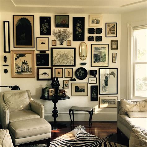 A Living Room Filled With Lots Of Framed Pictures On The Wall Above A