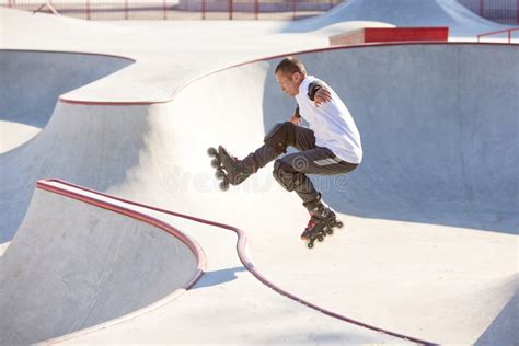 Mature Male Inline Roller Training In Public Skate Park Practicing Jumps Tricks Concept Of