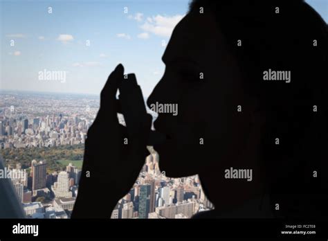Composite Image Of Asthmatic Brunette Using Her Inhaler Stock Photo Alamy