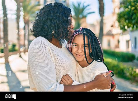 Beautiful African American Mother And Daughter Kissing And Hugging Standing With Smile On Face