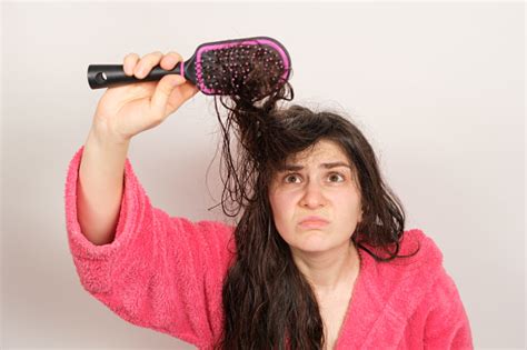 A Woman Tries To Comb Her Tangled Wet Hair Hair Care At Home Hair Loss