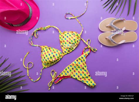 Summer Background With Palm Leaves Pink Fashion Hat Bikini And Flip Flops On Violet Or Purple