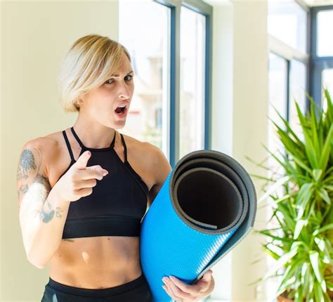 Premium Photo Pretty Blonde Woman Pointing With An Angry Aggressive Expression Looking Like A