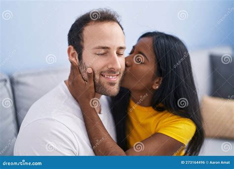 Man And Woman Interracial Couple Hugging Each Other And Kissing At Home