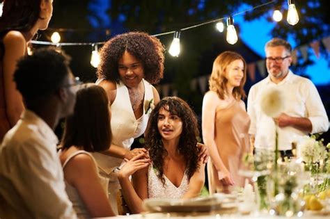 Premium Photo Happy Intercultural Lesbian Girls In Wedding Attire Talking To Their Friends