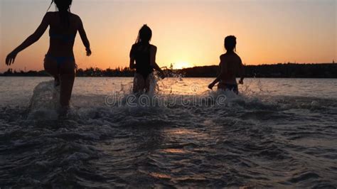 Chicas Mojadas Felices En Bikini Corren Al Mar Jugando Salpicar Agua Entre Ellas Al Atardecer