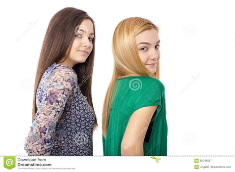 Deux Adolescentes Attirantes De Sourire Blondes Et Brune Pose Image