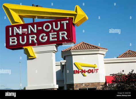 A logo sign outside of a In-N-Out Burger fast food restaurant location in American Fork, Utah on ...