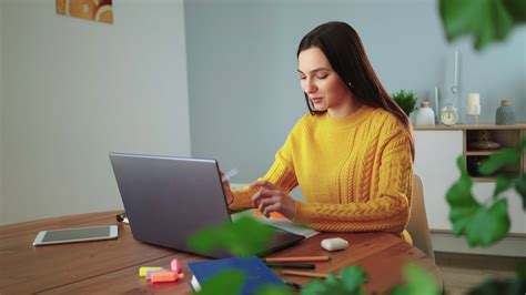 Lady student e learning using laptop webcam chat makes notes and