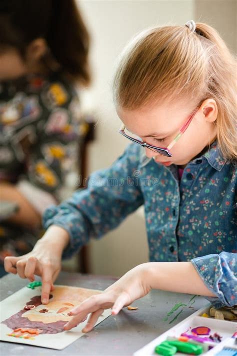 Portrait Of Blonde Girl With Big Black Glasses Smiling Happily While Enjoying Art And Craft
