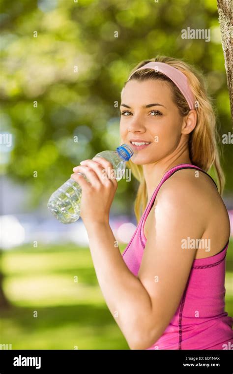 Fit Blonde Leaning Against Tree Drinking Water Stock Photo Alamy