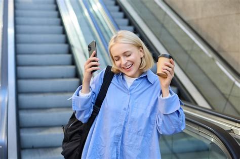 Image d une jeune femme blonde heureuse dansant de bonheur et de joie buvant du café à emporter