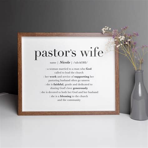 A Vase With Flowers Next To A Framed Poster That Says Pastors Wife On It