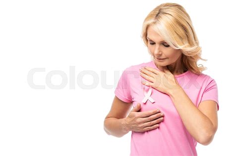 Blonde Woman Touching Breast And Looking At Pink Ribbon Of Cancer Awareness Isolated On White