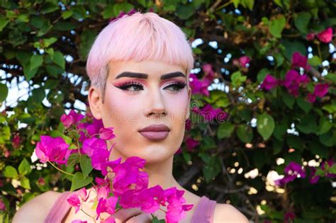 Retrato De Un Joven Gay Con Pelo Rosado Y Maquillaje Tiene Junto A Su Cara Una Flor De