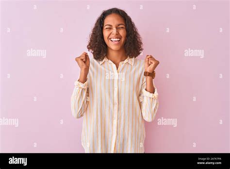 Young Brazilian Woman Wearing Striped Shirt Standing Over Isolated Pink