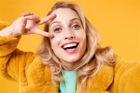 Gros Plan D une Jeune Femme Blonde Excitée En Manteau De Fourrure Jaune Posant Isolé Sur Fond