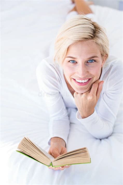 Smiling Blonde Woman Lying On The Bed And Reading A Book Stock Photo Image Of Homey Life