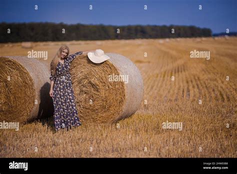 Une Jeune Fille Blonde Aux Cheveux Longs Dans Un Chapeau Blanc Se Repose Et Pose Pr S Des Gerbes