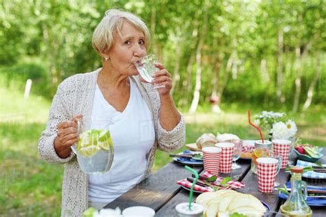 Thirsty Mature Woman Drinking Homemade Lemonade From Wineglass Royalty Free Stock Photo Dissolve