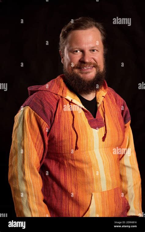 Solid Bearded Man In Bright Orange Clothe Smiling Studio Portrait On