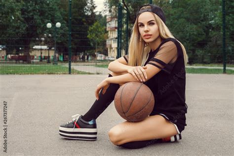 Beautiful Sexy Fitness Blonde Girl In Black Sport Wear With Perfect Body With Basket Ball At