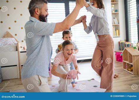 Father With Three Daughters Indoors At Home Playing On Floor Stock