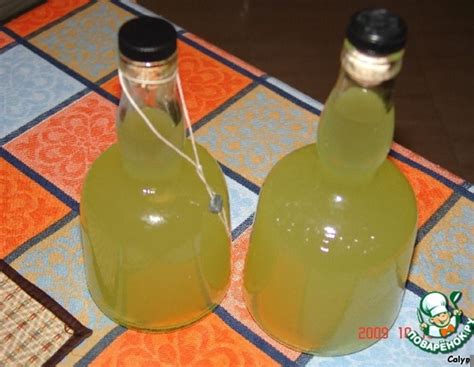 two bottles of green liquid sitting on top of a tiled floor next to ...