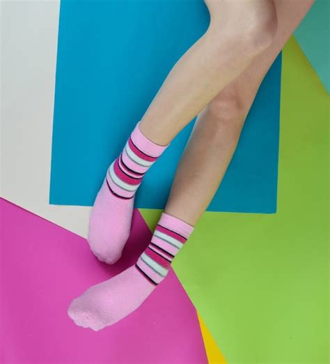 Premium Photo Naked Female Feet In Socks Posing On A Multi Colored Paper Wall Top View