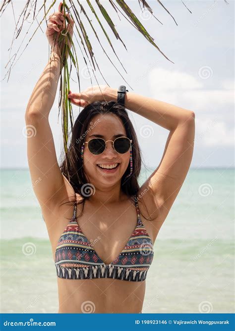 Asian Woman In Bikini Posture With Coconut Palm Leaf On Tropical Beach In Koh Kut Island