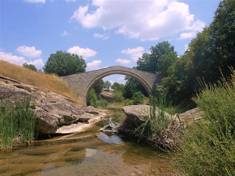 Premium Photo | A bridge over a creek with a creek and a bridge in the background.