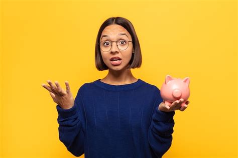 Joven latina que se siente extremadamente conmocionada y sorprendida ansiosa y en pánico con