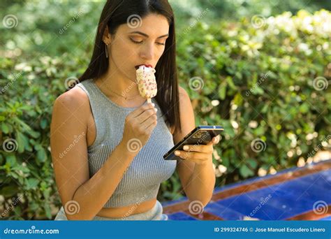 Mulher Latina Jovem E Linda Morena Consulta Seu Celular E Come Um Sorvete Refrescante Para