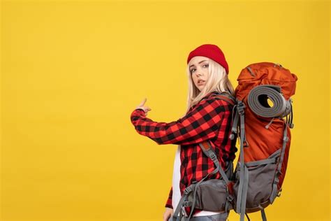 Vue De Face Fille Blonde Avec Son Sac à Dos Pointant Vers L arrière Photo Gratuite