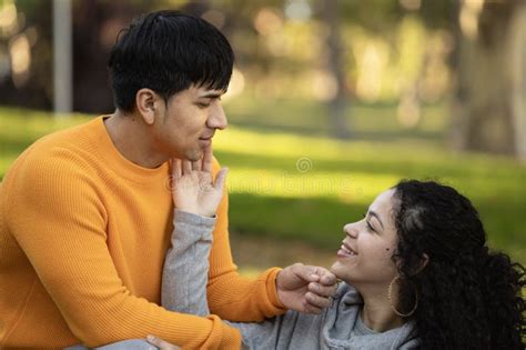 Mujer Latina Feliz Tocando La Cara De Su Novio Y Sentada En La Hierba Con Espacio Para Copiar