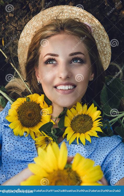 Jeune Femme Blonde Aux Cheveux Longs Chapeau De Paille Et Robe Bleue Sur Un Champ De Tournesols
