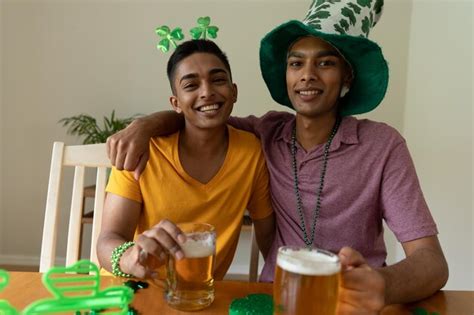 Premium Photo Smiling Mixed Race Gay Male Couple Wearing St Patrick S Day Costumes Embracing