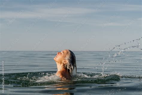 Mature Woman Swimming In The Sea And Playing With Water Stock Photo Adobe Stock