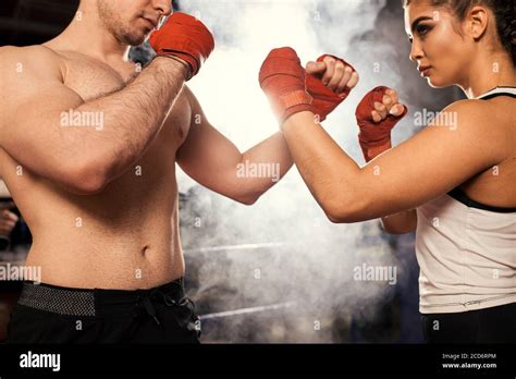 Fit Caucasian Trainer With Naked Torso And Sportive Female In White Top Fighting Boxing In Ring