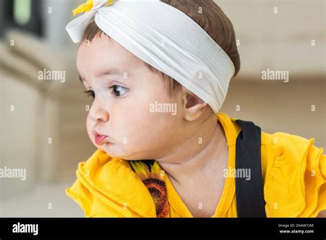 Beautiful Latina Baby Looking Curiously While Stretching Her Mouth As If To Give A Kiss Stock