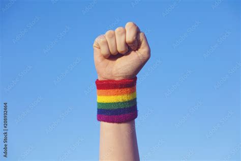 Gay Pride Concept Hand Making A Fist Sign With Gay Pride LGBT Rainbow Flag Wristband Stock