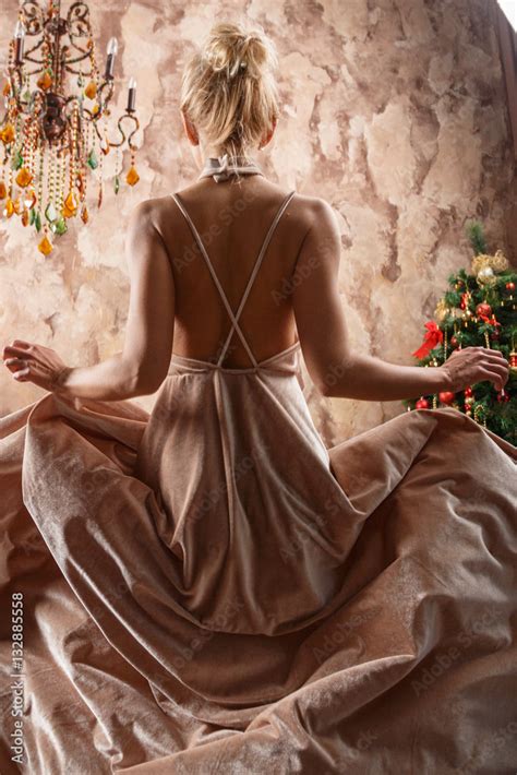 Beautiful Sexy Blonde In Dress Posing In A Castle By The Christmas Tree And Piano Stock Photo