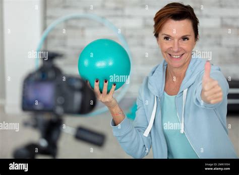 Mature Woman With Exercise Ball Filming Herself Working Out Stock Photo Alamy