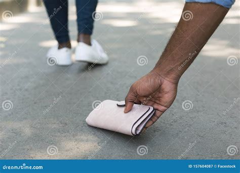 Guy Picking Up A Lost A Lost Purse Wallet Royalty Free Stock Photo